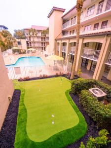 奥兰多Mai Hana Hotel的一座楼前庭院内带有高尔夫球的草坪
