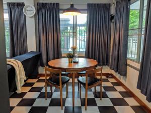 占那县Entire 2-storey house, 2 br, 2 toilet and shower, 2 car parks, only 400 m from MRT Huai Kwang的一间带桌椅和时钟的用餐室