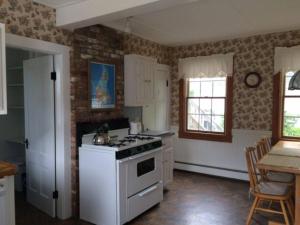 新肖雷汉姆The Harbourview Guest House & Cottages的厨房配有白色炉灶和桌子