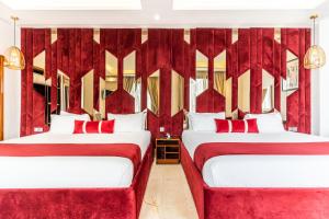 卡萨布兰卡One Hotel Casablanca的配有红色窗帘的客房内的两张床
