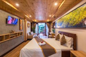 会安Art Villa Hoi An的一间酒店客房,配有一张床和一台电视