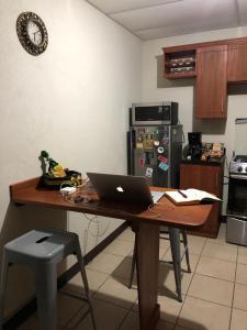 马那瓜Kami Hostel, Ciudad El Doral的厨房配有木桌和笔记本电脑