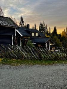 EidsvollKoselig rom i tømmerhus, inkl morgenkaffe的前面有木栅栏的房子