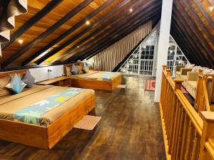 努沃勒埃利耶Cabin 7000 feet Nuwaraeliya的一间带两张床的卧室,位于木天花板的房间
