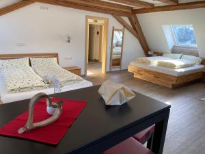 VöhrenbachGasthaus Kalte Herberge的一间设有两张床和一张红色地毯的桌子的房间