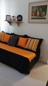 彼得罗波利斯Apartamento aconchegante em Petrópolis的橙色和黑色枕头的宿舍间内的一张床位