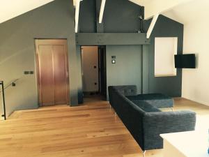 欧什家乡中心公寓的客厅设有黑色沙发和木地板