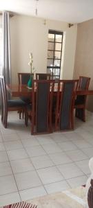 内罗毕MAMU'S RESIDENCE near JKIA的一间带木桌和椅子的用餐室