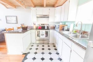 密尔沃基Milwaukie Riverfront Guest House的厨房配有白色橱柜和黑白格子地板。
