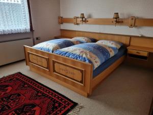 施瓦岑贝格Ferienhaus Buchen的一间卧室配有一张带蓝色棉被的木床