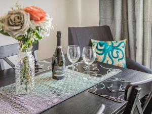 托基Lovely Magnolia Accommodation 3king Torquay的一张桌子,上面放着一瓶葡萄酒和两杯酒杯