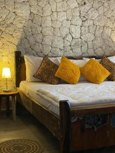 肯杜瓦Villa tangawizi kendwa的一张带黄色枕头和石墙的床