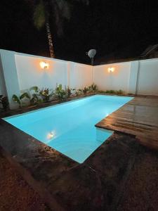 肯杜瓦Villa tangawizi kendwa的夜间大型蓝色游泳池,设有木甲板
