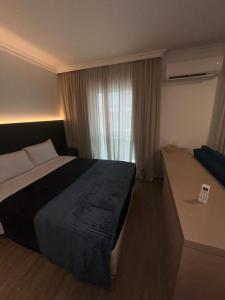 圣保罗HOTEL PERDIZES - FLAT Executivo - 504的酒店客房设有床和窗户。