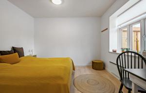 BredebroNice Home In Bredebro With Wifi的一间卧室配有一张黄色的床和一张桌子