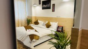 诺伊达Hotel Relax In - Noida Sector 18的一间卧室配有带白色床单和枕头的床。