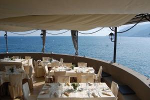 米诺利Antica Rheginna Luxury Room的一间设有白色桌椅的海洋餐厅