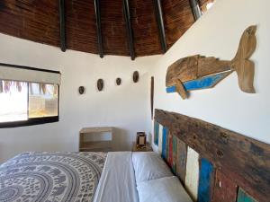 CanoasMarinus Eco Lodge的卧室配有一张床,墙上挂有木飞机