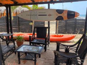 CanoasMarinus Eco Lodge的海滩上配有冲浪板的桌椅