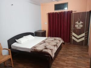 AyodhyaShri Niwas Homestay的一间卧室配有床和红色窗帘
