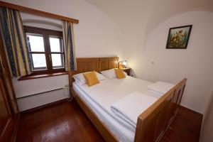 斯洛文尼亚科尼采兹拉提格力科葡萄酒大厦酒店的一间卧室配有一张带白色床单的床和一扇窗户。