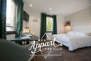佩里格Le Maleville - Balnéo & Ascenseur的酒店客房设有床、桌子、床和窗户。
