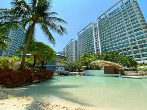 马尼拉Azure Staycation的一座棕榈树和建筑的游泳池