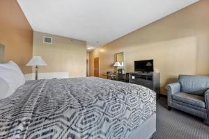 普廷贝Bayshore Resort at Put-in-Bay的酒店客房配有一张床、一把椅子和一台电视。