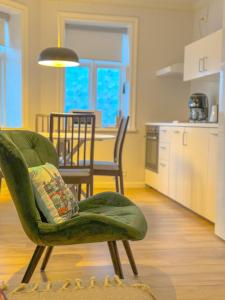 雷克雅未克Enjoy Reykjavík Yellow Door Apartment的一间带绿色椅子的客厅和一间厨房