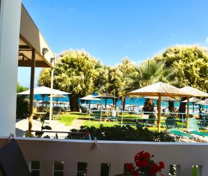 埃亚玛琳娜奈奇多Eden Beach Hotel的一个带桌子和遮阳伞的度假村和一个游泳池