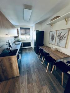 奥帕瓦Apartmán Opava s parkováním的厨房铺有木地板,配有木桌。