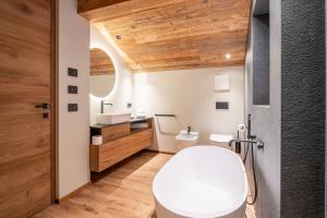 圣克里斯蒂娜Apartments Villa Sofia的一间带白色卫生间和木制天花板的浴室
