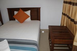 卡特勒格默UD Garden Hotel的小卧室配有带橙色枕头的床