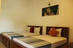 卡特勒格默UD Garden Hotel的一间设有两张床的房间和一张豹子的照片