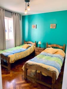 门多萨Departamento Centrico的蓝色墙壁客房的两张床