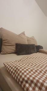 韦因加尔滕Stube 21的一张带两个枕头的床和一张 ⁇ 子毯子