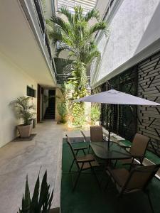 图卢姆Hotel Boutique Murana Tulum的庭院配有桌椅和遮阳伞。