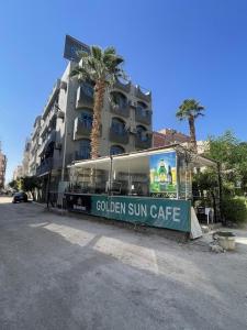 赫尔格达Golden Sun Hotel - Hurghada的建筑物前读金色太阳门的标志