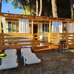 阿梅利亚International Holidays Luxe House Pool Beach-Lerici-Cinque Terre-Liguria Case Vacanze in Touristic Village River的大型木屋,配有两把椅子和烧烤架