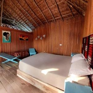 OuidahBel Ami的卧室设有白色大床和木墙