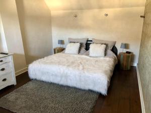 RiedenFerienhaus Eifel-Auszeit的卧室配有一张带白色床单和枕头的大床。