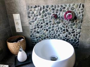 RiedenFerienhaus Eifel-Auszeit的浴室配有白色水槽和石墙