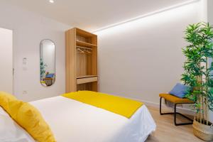 阿尔巴塞特Apartamentos TriBeca Centro II的一间卧室配有一张床、一把椅子和镜子