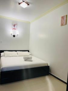 巴尼奥斯Hostal Balcon del Cielo的白色墙壁间的一张床位