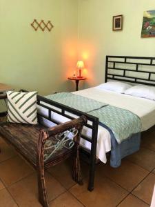 CarrillosSERENITY BY NATURE的一间卧室配有一张大床和一张长凳