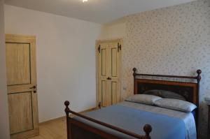 PortariaRes Nova Il Colle的一间卧室配有一张带木制床架的床