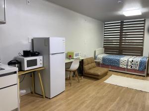 济州市Stay SonSu的一间小房间,配有冰箱和一张床