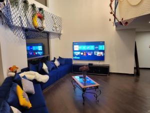 迪拜Atlantis View Hostel的客厅配有蓝色的沙发和电视