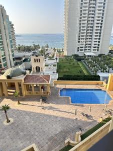 迪拜Atlantis View Hostel的享有带游泳池的建筑的空中景致