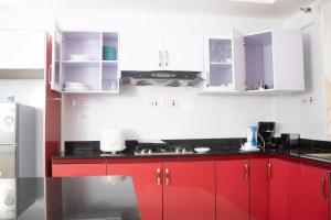 内罗毕4bedroom Navilla westlands Nairobi的厨房配有红色橱柜和黑色台面